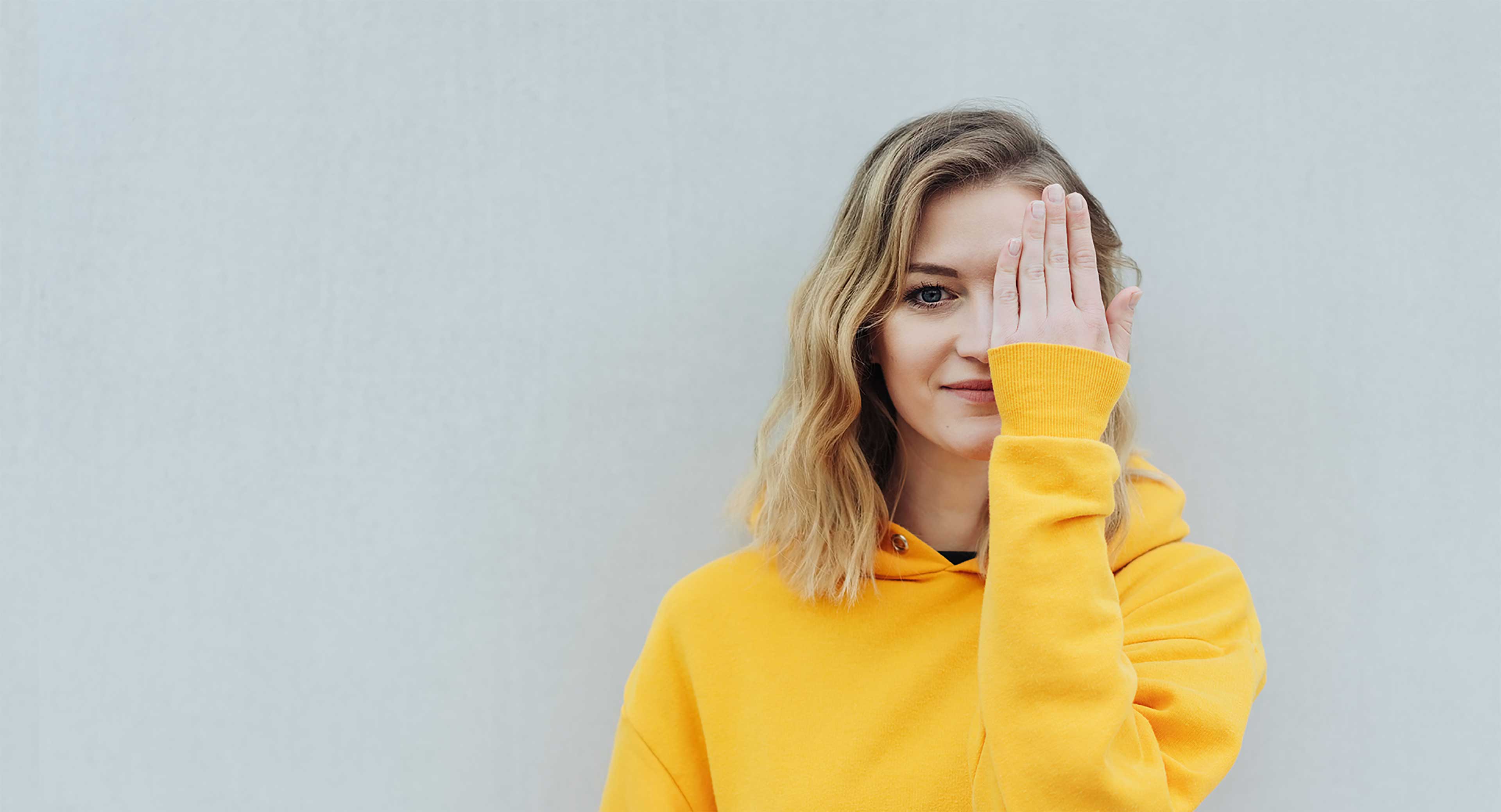 Girl covering one eye with her hand